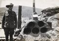 Australian soldier beside makeshift camp: an oven made from earth and petrol tins